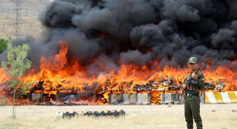 An Iranian policeman stands guard as 50 tonnes of illegal drugs are destroyed during a ceremony on June 27, 2015 in the northeast city of Mashhad