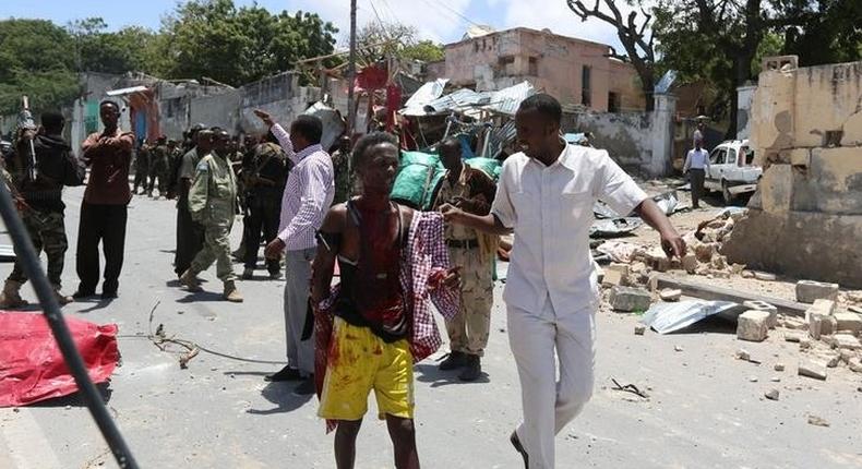 A civilian wounded following a car bomb claimed by al Shabaab Islamist militants  outside the president's palace is escorted as he walks from the scene of the explosion in the Somali capital of Mogadishu, August 30, 2016. REUTERS/Feisal Omar