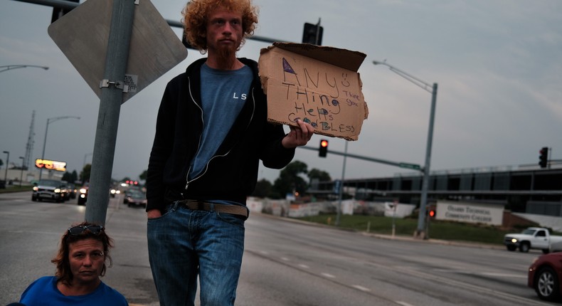 Mathew and his girlfriend Vicki, who are both homeless, panhandle on a street on August 05, 2021 in Springfield, Missouri.