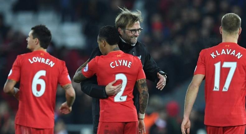 Liverpool manager Jurgen Klopp (2R) hugs hisdefender Nathaniel Clyne (2L) after the English Premier League match against Stoke City at Anfield in Liverpool, north-west England on December 27, 2016