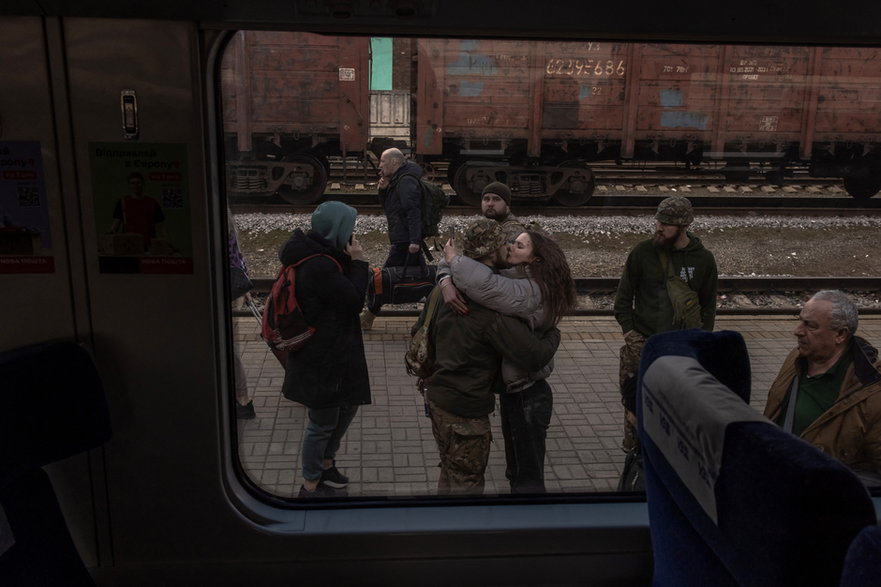 Ukraiński żołnierz całuje swoją partnerkę, która przyjechała pociągiem z Kijowa