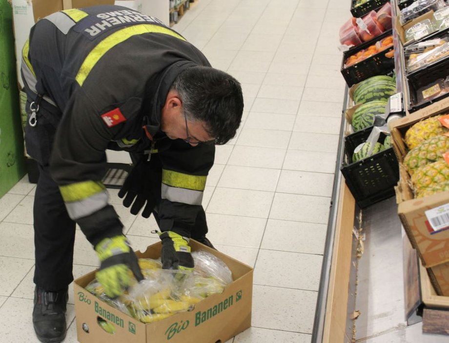 Strażak przeszukuje pojemniki z bananami