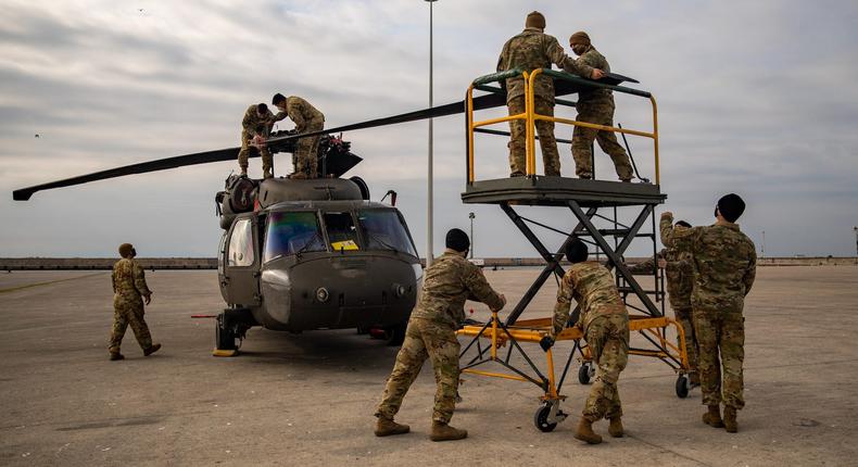 US soldiers fold the blades of a UH-60 Black Hawk helicopter at the port of Alexandroupoli in Greece, November 18, 2021.