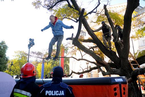 Członek Lotnej Brygady Opozycji skacze z drzewa przy galerii Zachęta podczas miesięcznicy smoleńskiej 10 października 2021 roku