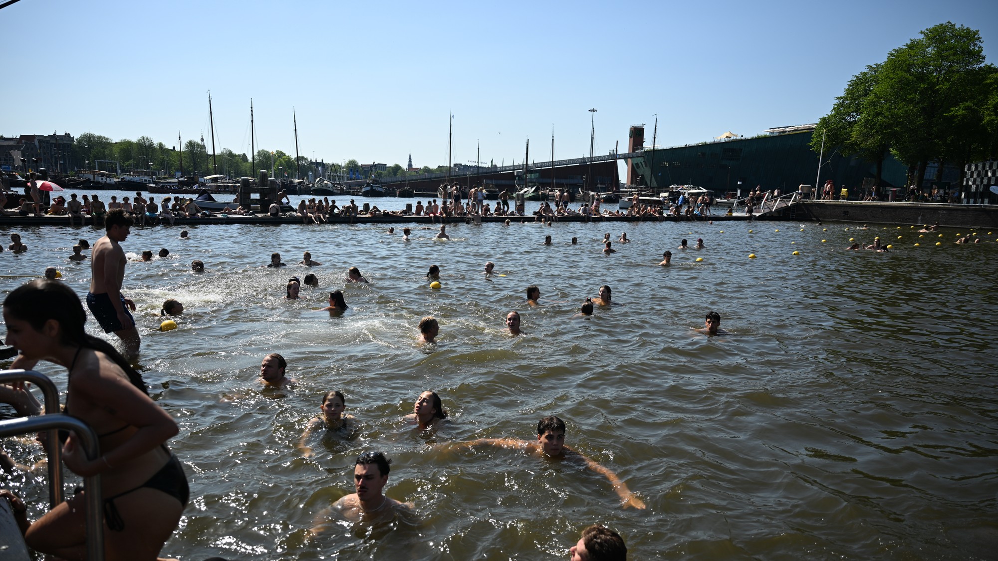 Ľudia plávajú vo vodnom kanáli počas vlny horúčav v holandskom Amsterdame 25. júna 2026.
