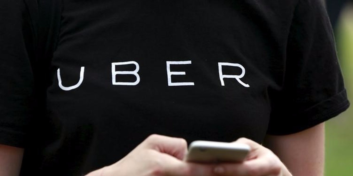 An Uber representative registers people on a smartphone during a jobs tour in Queens in New York City.