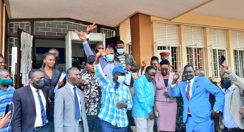 Besigye (in sky blue hat) and supporters outside court