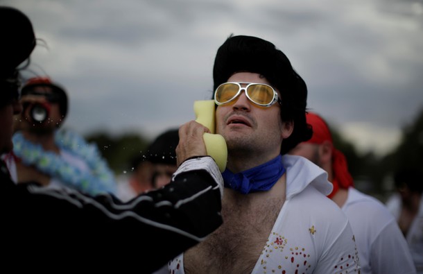 An amateur rugby player dressed as Elvis Presley from the Blue Suede Shoes team gets a wet sponge-do