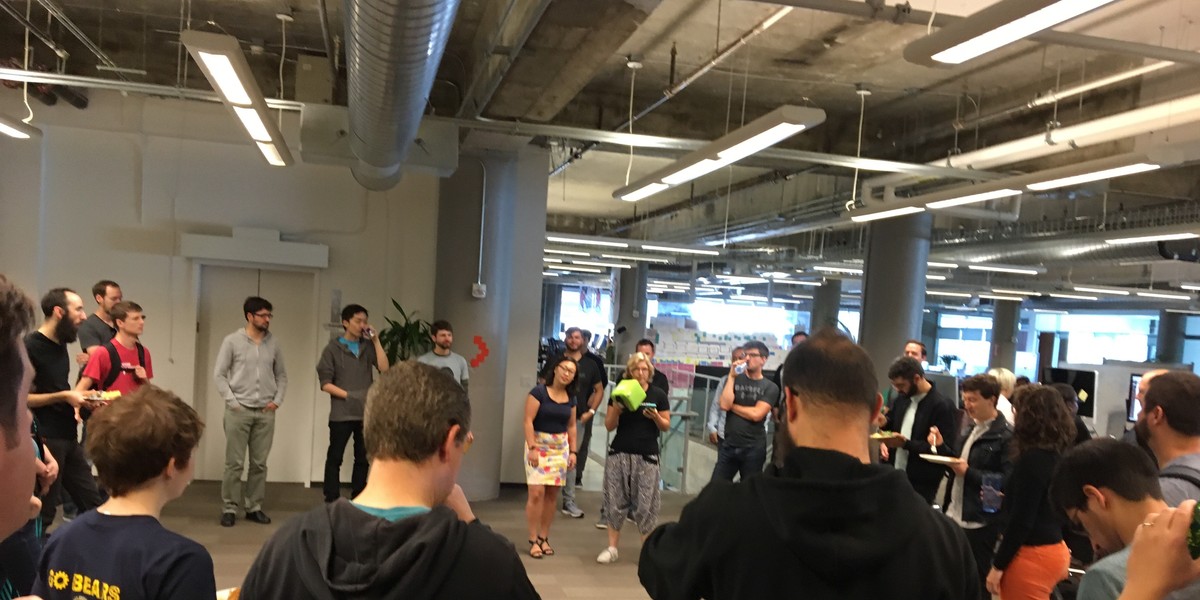 The first, and biggest, mandatory 5-minute meeting of the day. Note the green plush box, which contains the microphone, and which gets tossed to the next speaker.