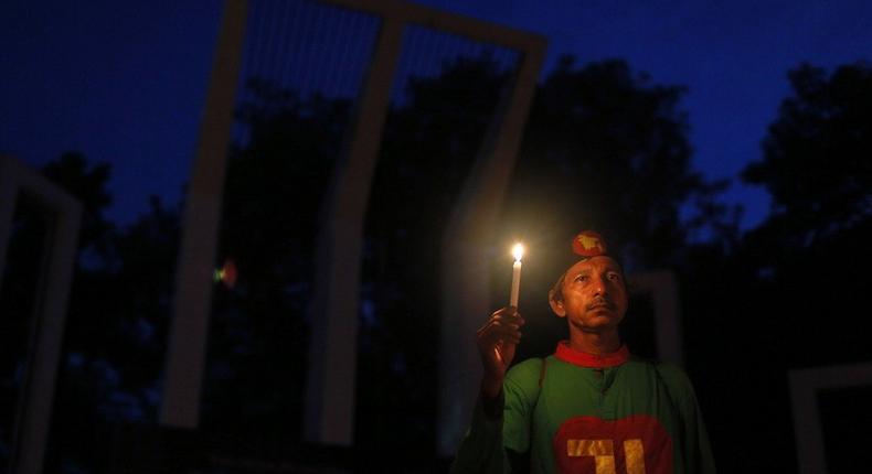 A Bangladeshi activist holds a candle, as they protest against the killing of secular blogger Niloy Chakrabarti in Dhaka, Bangladesh.