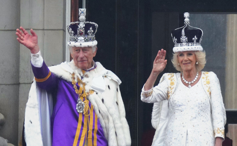 Król Karol III i królowa Kamila machają do tłumów przed pałacem Buckingham tuż po ceremonii koronacji, 7 maja 2023 r.