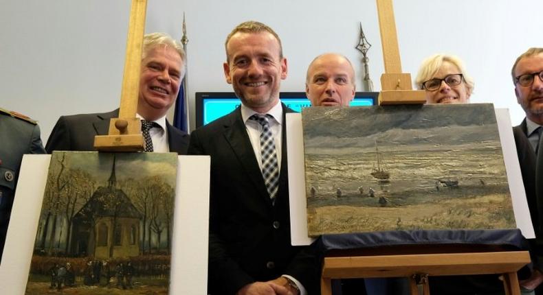 Axel Ruger (C), Director of the Van Gogh museum, poses next to recovered stolen paintings by Vincent Van Gogh entitled Congregation Leaving the Reformed Church in Nuenen (L) and The Beach At Scheveningen During A Storm (R) in Naples in 2016