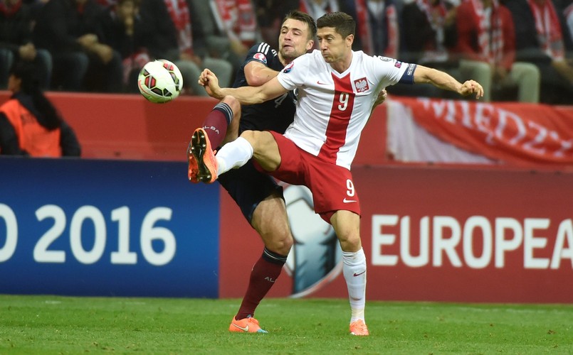 Polak Arkadiusz Milik (L) fetuje z Arturem Jędrzejczykiem (P) strzelenie bramki drużynie Szkocji na 2-2 podczas meczu eliminacyjnego piłkarskich mistrzostw Europy