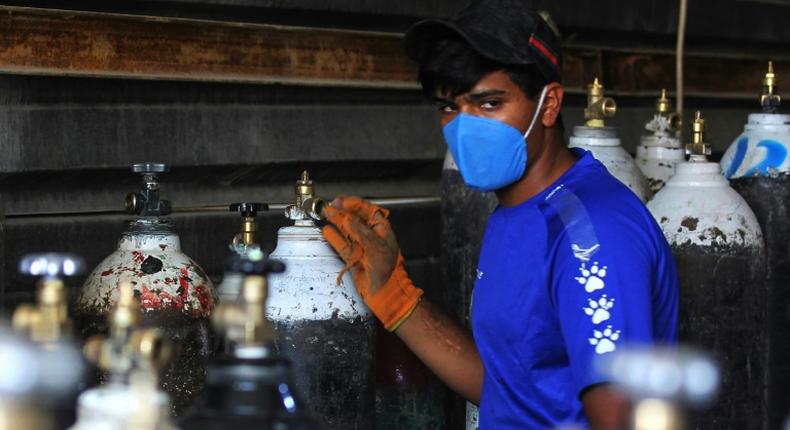 A worker refills oxygen cylinders at a factory in Taji district north of Iraq's capital Baghdad, before delivering them to hospitals amid the COVID-19 pandemic