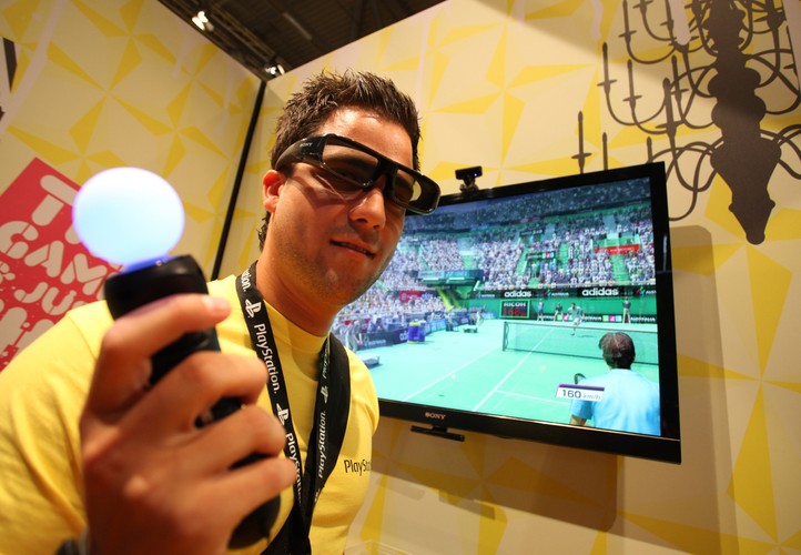 Pracownik Sony w okularach 3D prezentuje wykrywający ruchy kontroler do gier 'Move'