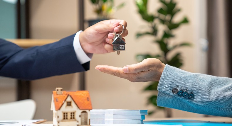 A realtor exchanging keys with a homebuyer.Getty Images