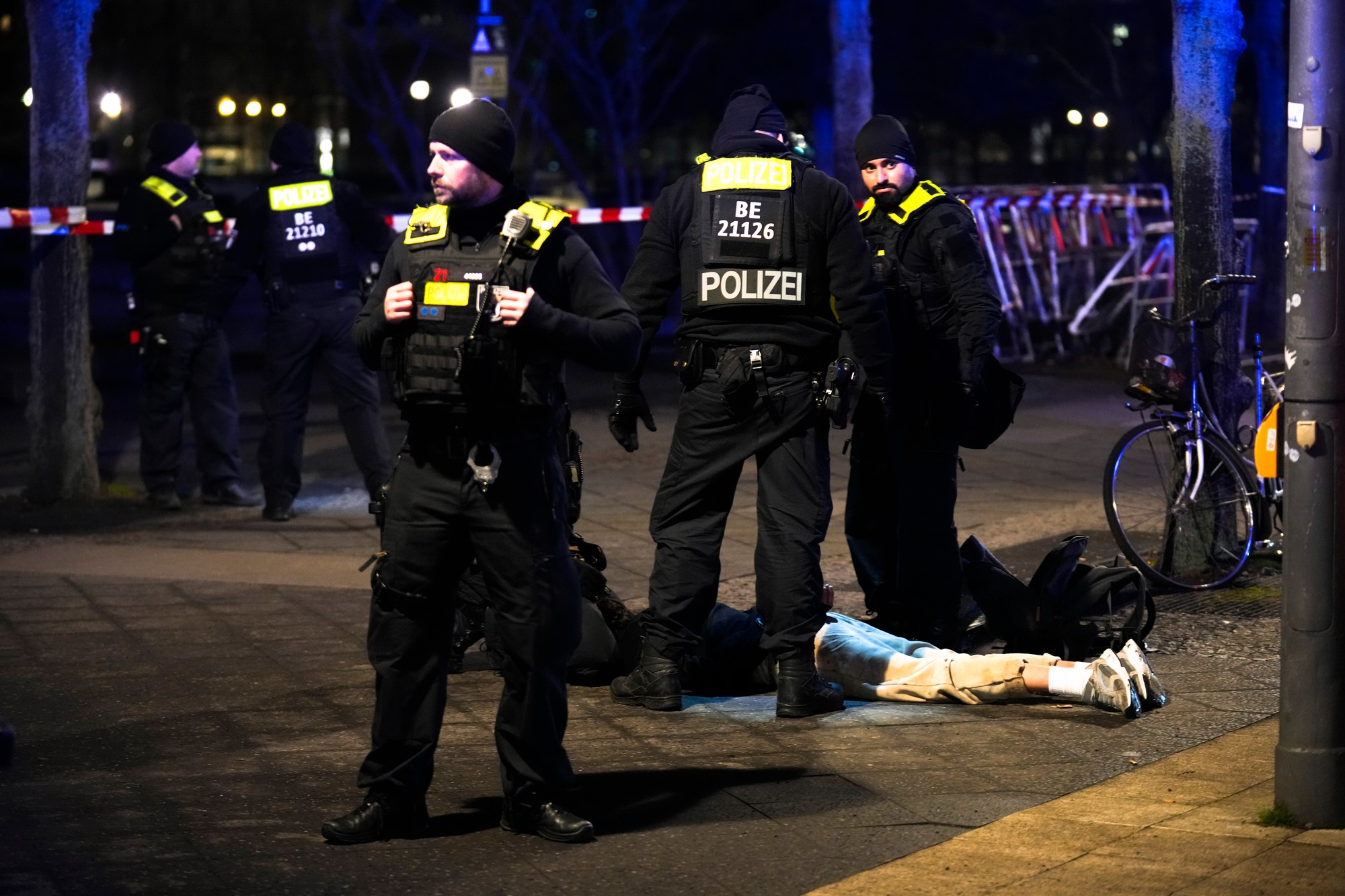 Policajti zadržiavajú muža pri pamätníku holokaustu v nemeckom Berlíne po tom, ako bol iný muž vážne zranený, piatok 21. februára 2025.