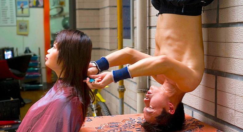 Wang Xiaoyu giving a model a haircut near his barbershop in Changsha, in China's Hunan province, in 2009.