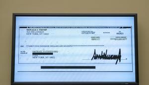 FILE - A copy of a check from Donald Trump to Michael Cohen, his former personal lawyer, is displayed as Cohen testifies before the House Oversight and Reform Committee on Capitol Hill in Washington, Wednesday, Feb. 27, 2019. Trump has become the first former president to be indicted in a criminal case after a grand jury investigation into hush money payments made on his behalf during the 2016 presidential campaign. (AP Photo/J. Scott Applewhite, File)