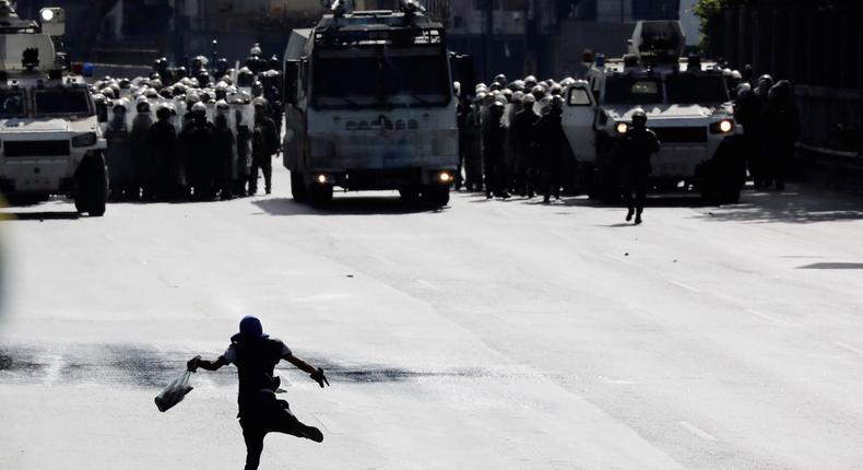 Security forces take position in front of a demonstrator during rallies against Venezuelan President Nicolas Maduro in Caracas.