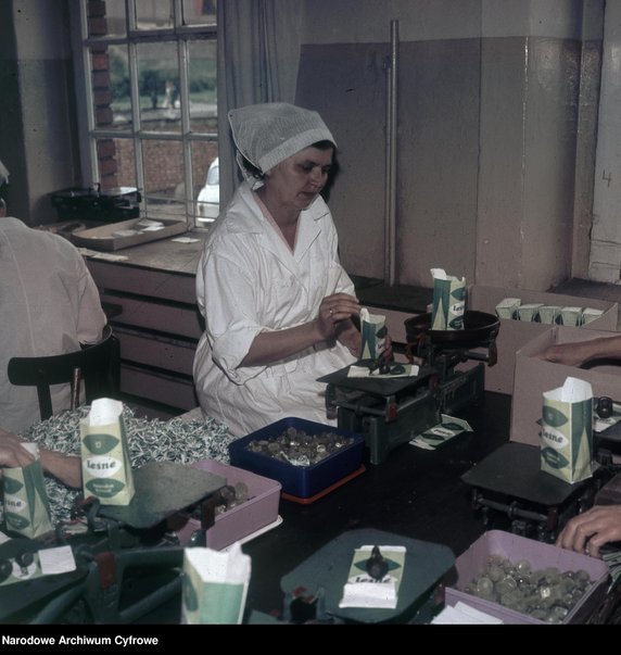 Kobieta pakująca cukierki "Leśne — łagodzą kaszel" do papierowej torebki. Fabryka Cukrów i Czekolady "Ślązak" w Raciborzu - 1970 r.  - Narodowe Archiwum Cyfrowe