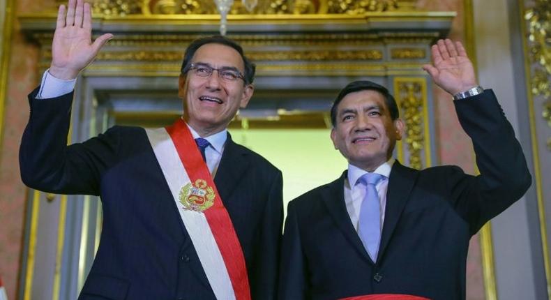 Handout picture released by the Peruvian presidency press office of President Martin Vizcarra (L) and newly appointed Interior Minister Carlos Moran, waving during a swearing-in ceremony at government headquarters in Lima on October 19, 2018.