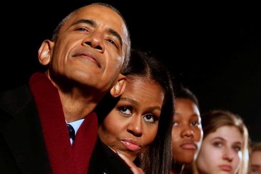 Obama and the first lady cuddle together as they participate in the National Christmas Tree lighting in Washington