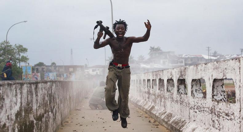 Joseph Duo, a Liberian militia commander loyal to the government, exults after firing a rocket-propelled grenade at rebel forces at a key strategic bridge July 20, 2003 in Monrovia, Liberia. Government forces succeeded in forcing back rebel forces in fierce fighting on the edge of Monrovia's city center.