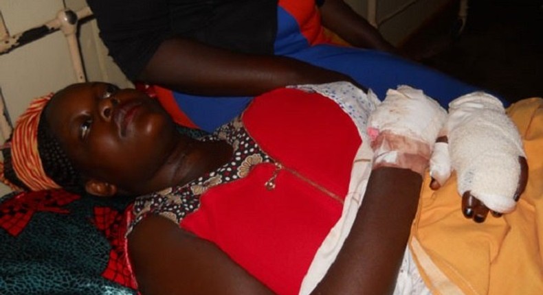 Olivia Nangozi on her hospital bed after her husband slit her neck