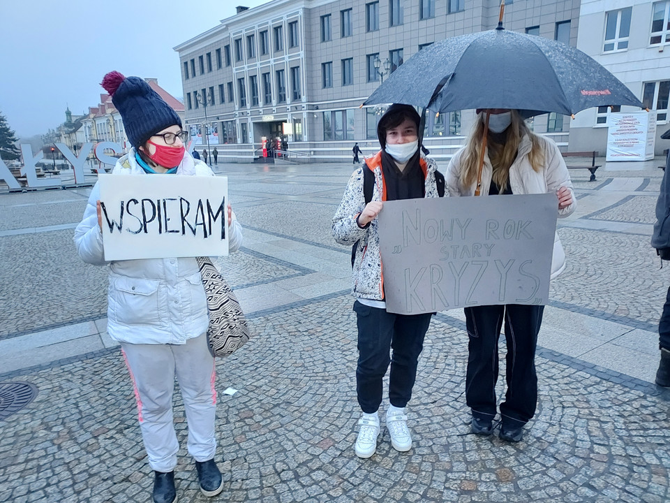 Młodzież z transparentami na proteście "Nowy rok, stary kryzys" w Białymstoku, 2.01.2022.