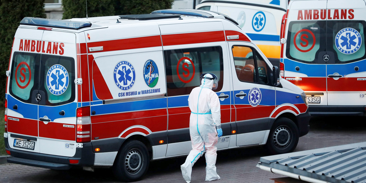 A paramedic walks near an ambulance amid the coronavirus disease (COVID-19) outbreak, in front of a 