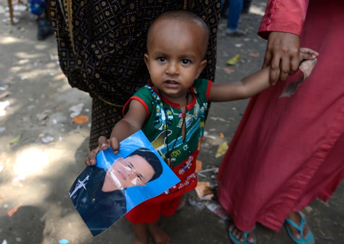 Kilkuletni chłopiec pokazuje zdjęcie ojca, który zaginął w katastrofie
