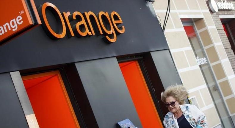 A woman walks past an Orange shop in Madrid, September 16, 2014. REUTERS/Andrea Comas