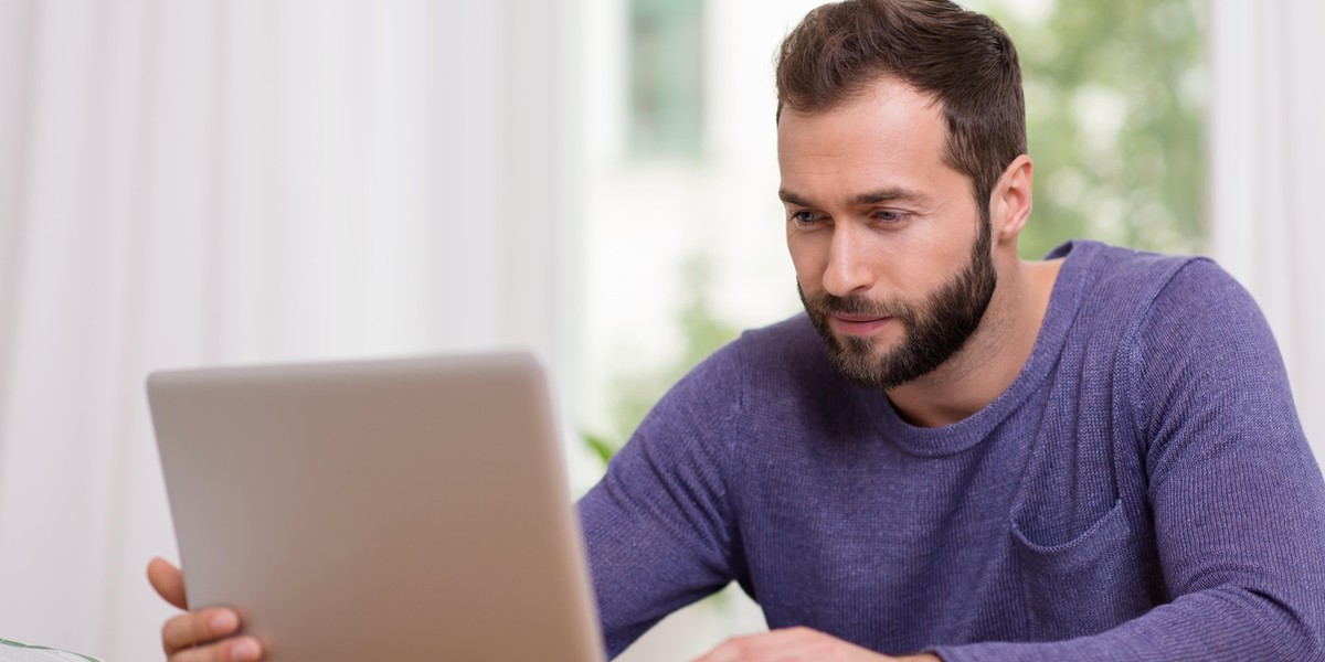 Man working on his laptop computer at home