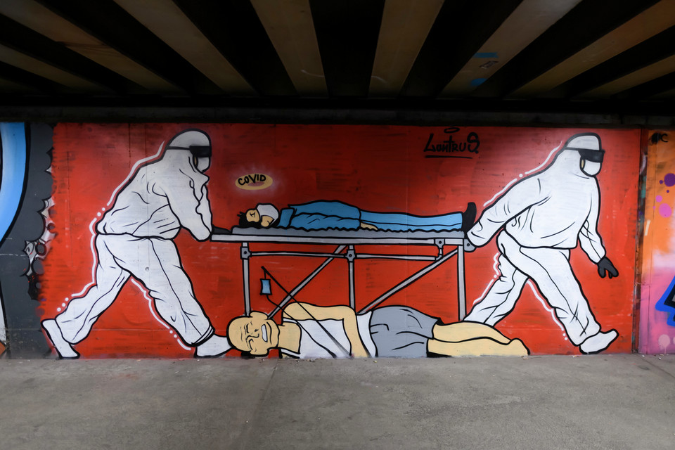 Poznań, 8.01.2021. Koronawirus w Polsce. Graffiti "Covid" autorstwa Luntrusa przedstawiające ratowników medycznych i pacjentów na noszach.