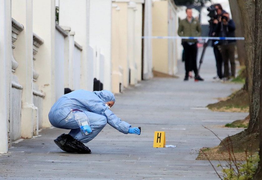 Police forensics officer works at the site where police fired shots after a vehicle rammed the parke