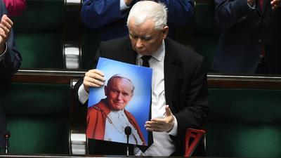Jarosław Kaczyński z obrazkiem przedstawiającym Jana Pawła II w trakcie sejmowej debaty nad uchwałą w obronie dobrego imienia polskiego papieża