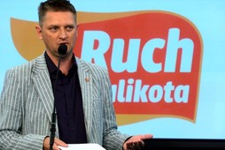 Andrzej Rozenek na tle logo Ruchu Palikota