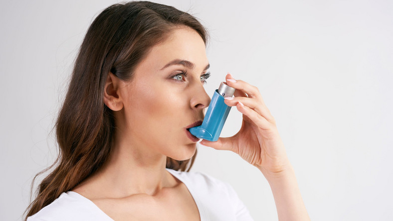 Kobieta używa inhalatora, astma