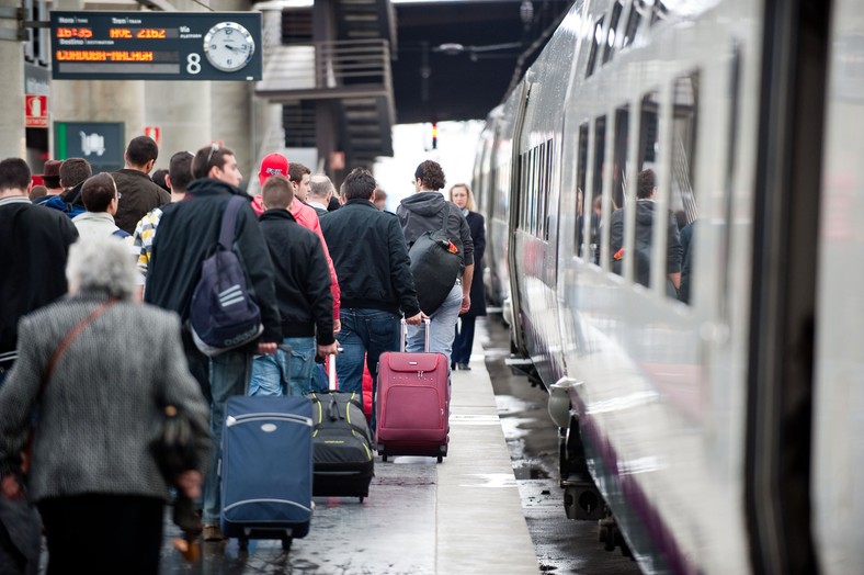 Pasażerowie wsiadający do szybkiej kolei AVE hiszpańskiej sieci kolejowej RENFE na stacji Madryt-Atocha (2). Fot. Bloomberg.