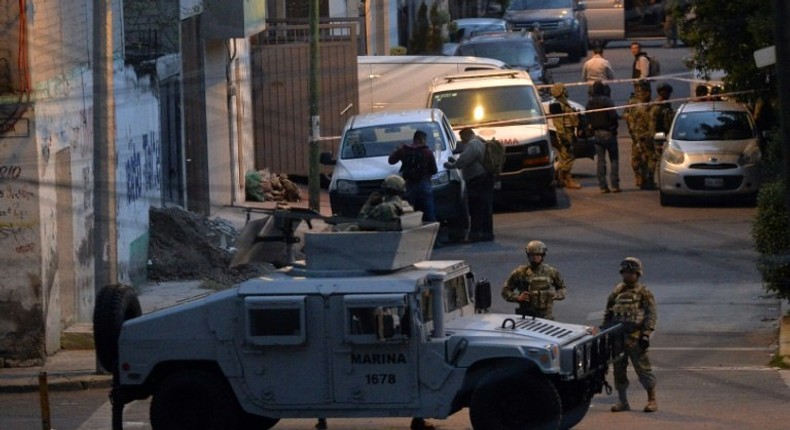 Mexican Marines stand guard after eight alleged criminals were shot dead in a rare shootout in the nation's capital