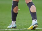 Why do so many footballers cut holes in their socks?