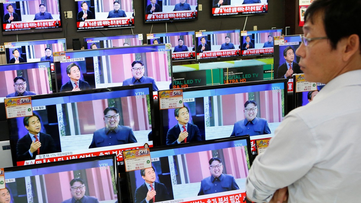 A sales assistant watches TV sets broadcasting a news report on North Korea's fifth nuclear test, in