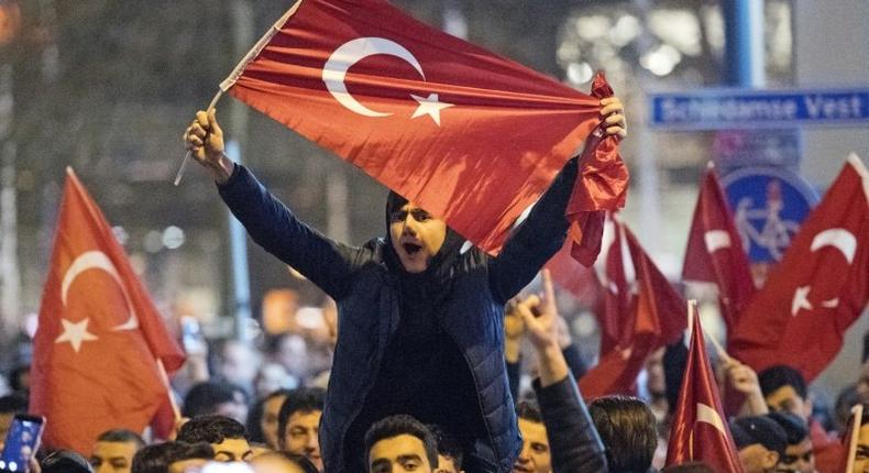 People wave Turkish national flags during a demostration near the Turkish consulate in Rotterdam on March 11, 2017