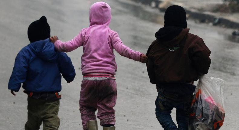 Children walk together as they flee deeper into the remaining rebel-held areas of Aleppo, Syria December 13, 2016.