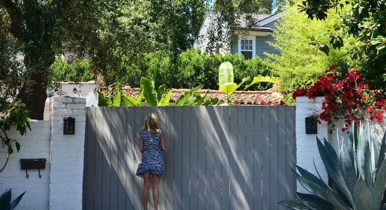 A woman tries to look over the gate of the house where Marilyn Monroe died in Brentwood.FREDERIC J. BROWN/Getty Images