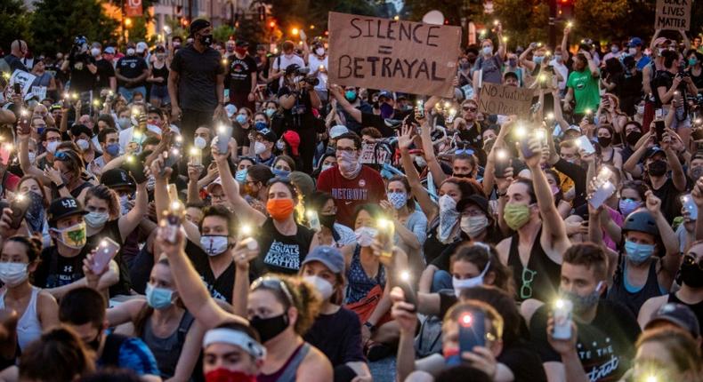 Protestors in Washington hold up their phones at a march on June 3