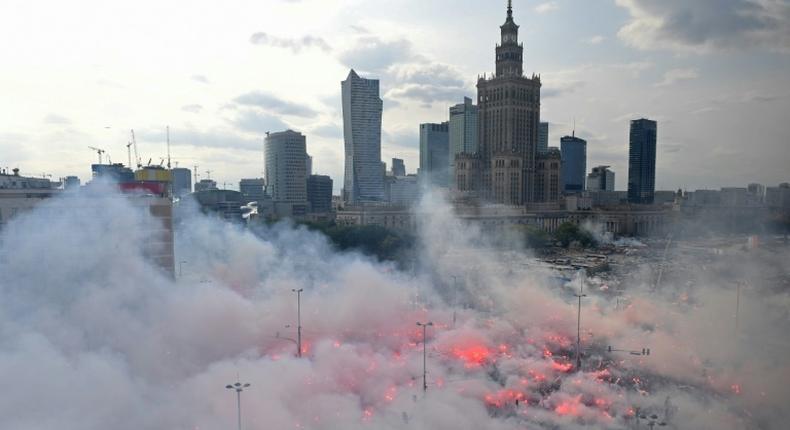 People lit flares as they observed a minute of silence to mark the 75th anniversary of the Warsaw Uprising against the Nazi occupiers during World War II