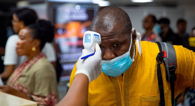 A traveller getting his temperature checked  at the airport