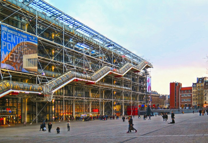 <strong>Centre Georges Pompidou (Musée National d’Art Moderne)</strong>
<br></br>
Właściwie dlaczego nie uczynić z rur, kabli i innych elmentów instalacji budynków ozdoby i dzieła sztuki architektonicznej? Na taki postmodernistyczny pomysł (pokazania rur i instalacji na fasadzie budynku) wpadli dwaj projektanci - Renzo Piano i Richard Rogers - którzy wygrali konkurs na koncepcję centrum kulturalnego w paryskiej dzielnicy Beaubourg. Prowokujące swoim awangardowym wyglądem centrum nosi imię Georgesa Pompidou - prezydenta Francji, który zainicjował budowę tego gmachu. We wnętrzach mieści się muzeum pokazujące dzieła sztuki współczesnej oraz biblioteka.